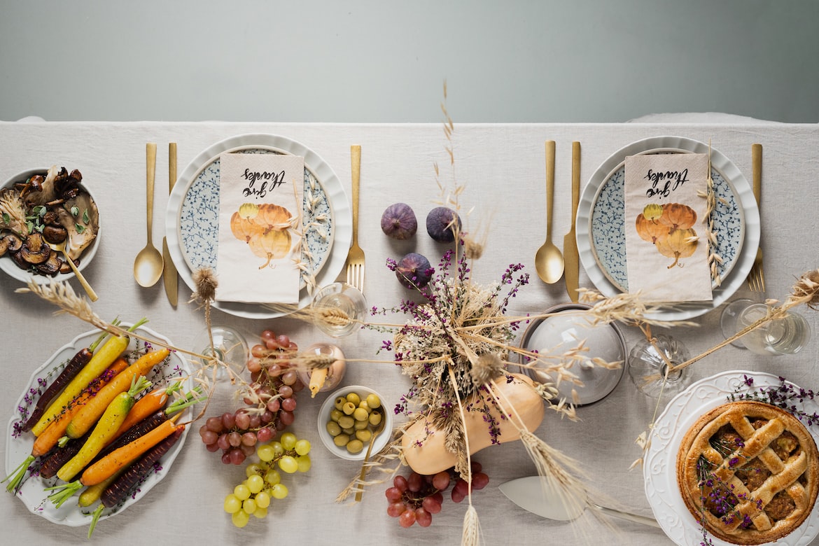 Thanksgiving dinner decorations with napkins, candles, and dinnerware