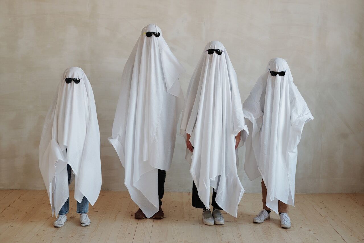A family is wearing ghost costumes