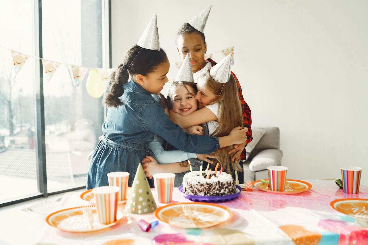 Four girls hugging during a birthday party