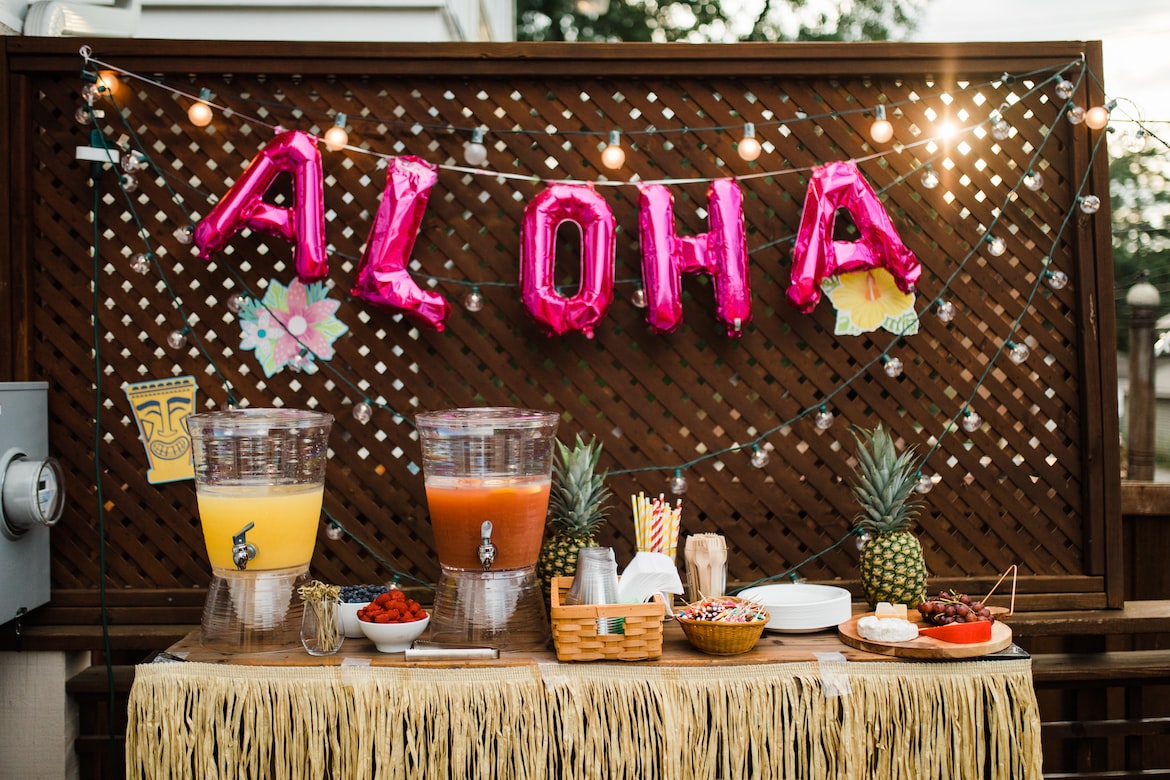 Table of food and drinks at a tiki-themed party